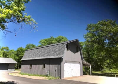 Residential asphalt shingles roof replacement completed on gray barn