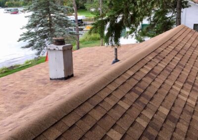 Asphalt roof replacement completed on lake home with red shingles