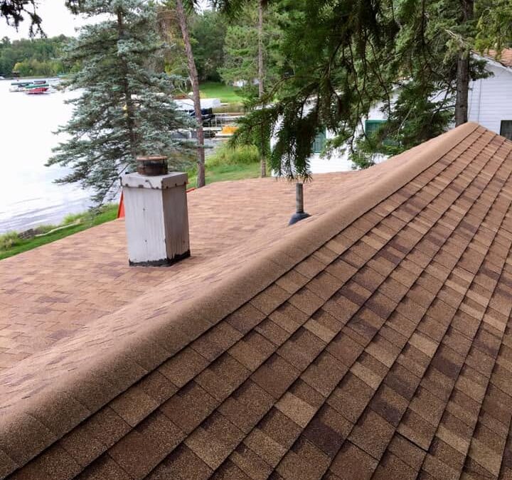 Asphalt roof replacement completed on lake home with red shingles