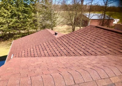 Residential asphalt roof replacement completed with red shingles
