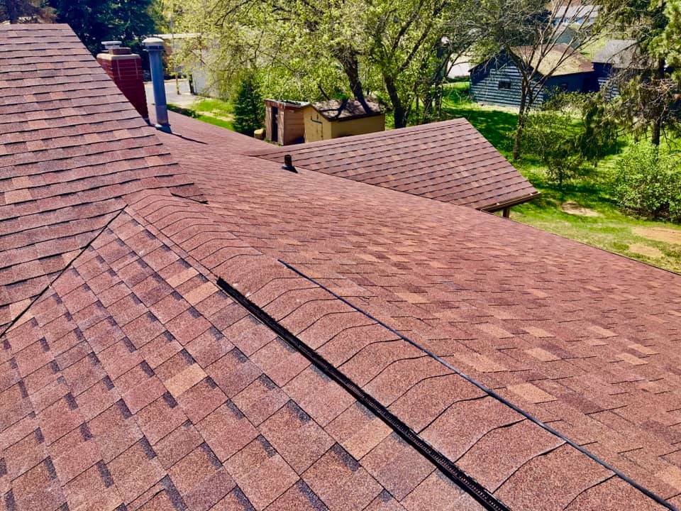 Residential asphalt roof replacement completed with red architectural shingles