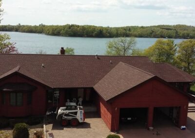 Residential asphalt roof replacement completed red shingles air view