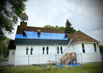 Asphalt roofing white church building job in progress