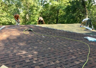 Residential roof work in progress with brown asphalt shingles