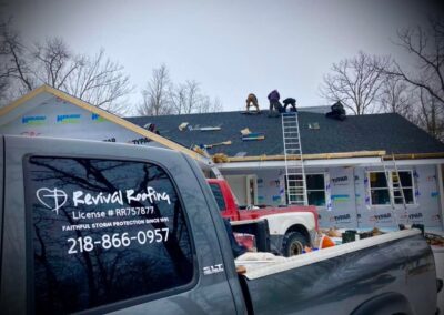 Residential asphalt shingles roof replacement in progress with dark gray shingles