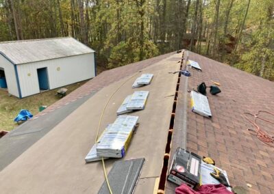 asphalt shingles roof replacement in progress with red shingles