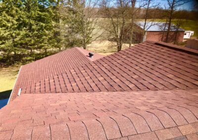 Residential roof replacement job completed with red shingles