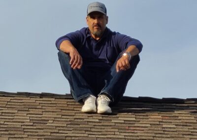 Robert Aguirre sitting on residential roof