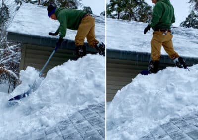 Deep roof snow removal in progress with crew member
