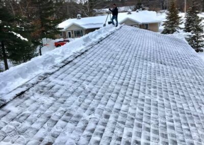 Roof snow removal on residential home half complete